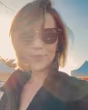 Adrienne L., CEO, wearing sunglasses in a sunlit outdoor selfie.